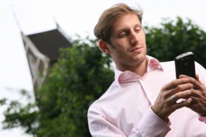 Man using Windows Mobile device keypad outside